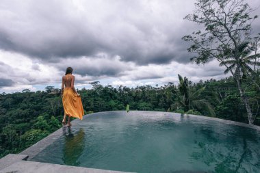 zarif sarı elbise li koyu saçlı güzel kadın poz