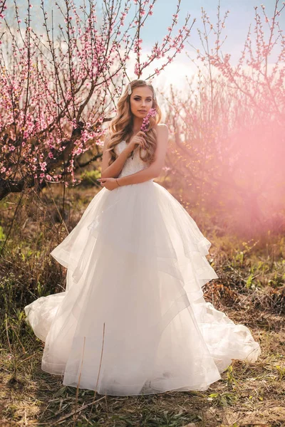 Schönes Mädchen mit blonden Haaren im eleganten Hochzeitskleid posiert — Stockfoto