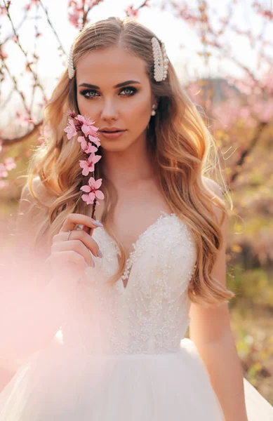 Vacker flicka med blont hår i elegant bröllop klänning poserar — Stockfoto