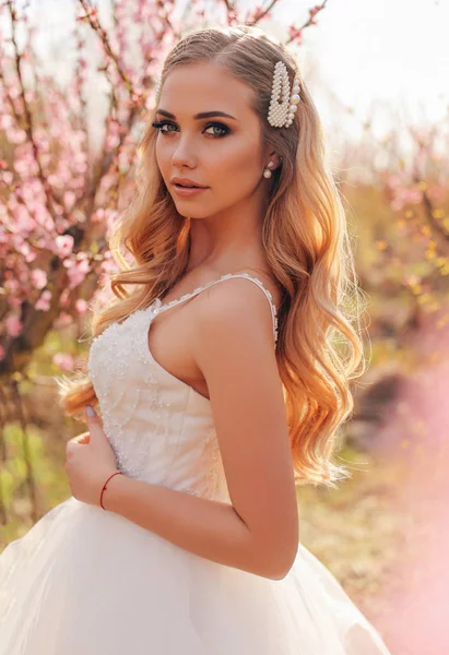 Красивая девушка с светлыми волосами в элегантном свадебном платье позируя — стоковое фото