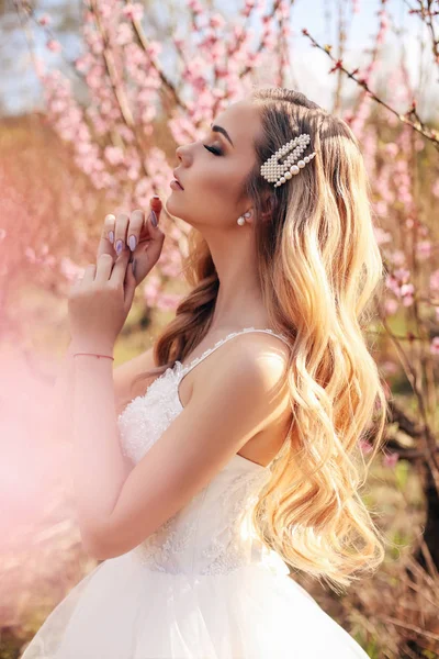 Belle fille aux cheveux blonds dans une élégante robe de mariée posant — Photo