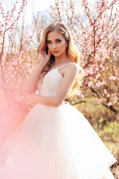 Bella ragazza con i capelli biondi in elegante abito da sposa in posa — Foto Stock