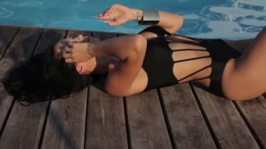açık yüzme havuzu yakınında rahatlatıcı zarif yüzme elbisesi koyu saçlı güzel seksi kadın video