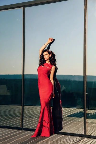 Vacker sensuell kvinna med mörkt hår i elegant röd klänning posi — Stockfoto