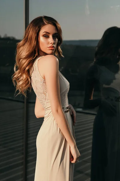 Bela mulher com longos cabelos loiros em luxuoso vestido bege po — Fotografia de Stock