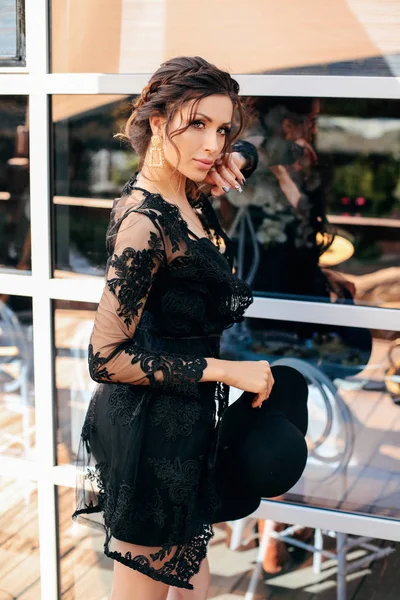 Schöne sexy Frau mit dunklen Haaren in elegantem schwarzen Kleid und h — Stockfoto