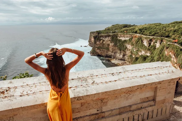 亚洲旅游系列 美丽的女人 黑头发 穿着优雅的黄色连衣裙 欣赏海洋的全景 — 图库照片