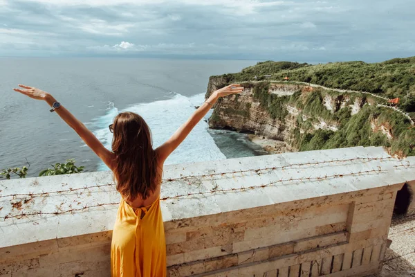 亚洲旅游系列 美丽的女人 黑头发 穿着优雅的黄色连衣裙 欣赏海洋的全景 — 图库照片