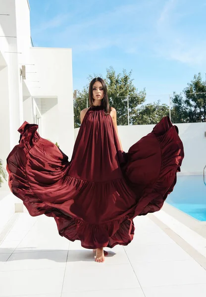 Jonge vrouw met donker haar in luxe zomer jurk ontspannen ne — Stockfoto