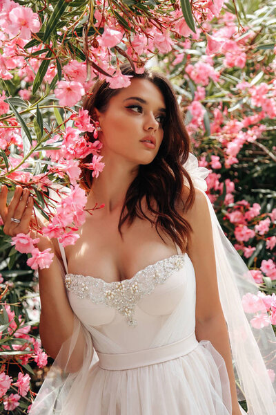 beautiful woman with dark hair in luxurious wedding dress posing