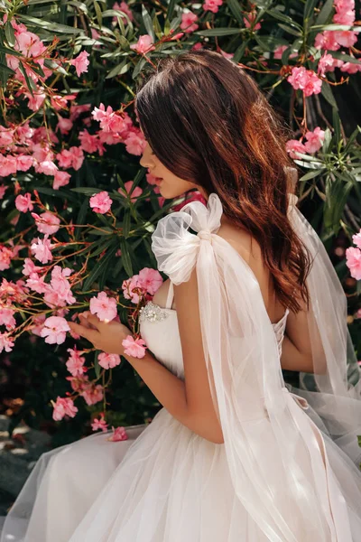 Schöne Frau mit dunklen Haaren in luxuriösem Hochzeitskleid posiert — Stockfoto