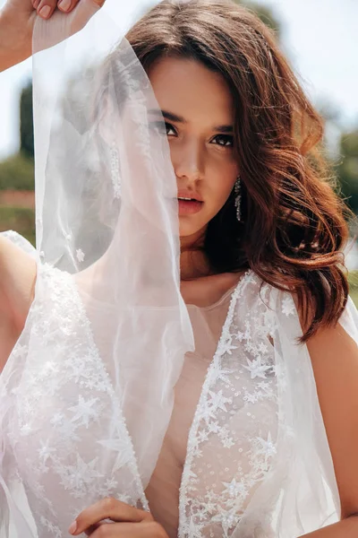 Красивая женщина с темными волосами в роскошном свадебном платье — стоковое фото