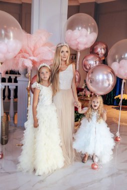 Sarışın, kıvırcık saçlı, zarif elbiseli güzel bir kız.