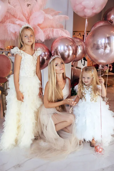 Sarışın, kıvırcık saçlı, zarif elbiseli güzel bir kız.