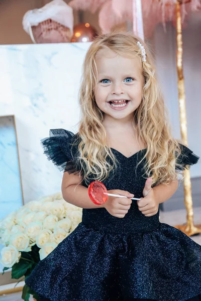 Sarışın, kıvırcık saçlı, zarif elbiseli güzel bir kız.