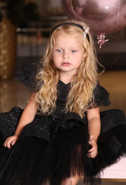 Beautiful small girl with blond curly hair in elegant dress cele — Stock Photo, Image