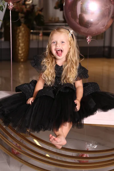 Beautiful small girl with blond curly hair in elegant dress cele — Stock Photo, Image