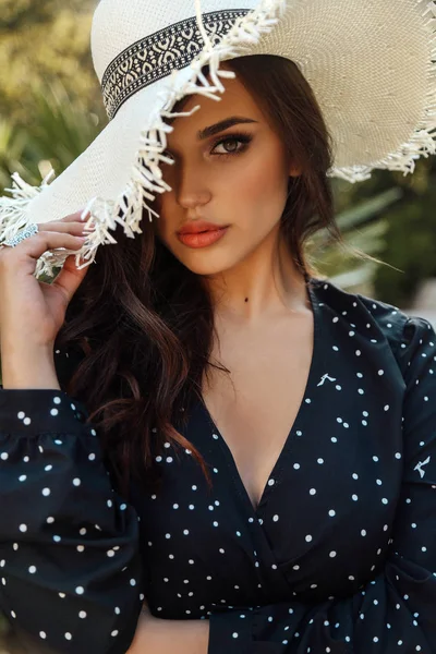 Vacker kvinna med mörkt hår i elegant klänning poserar på sommaren — Stockfoto