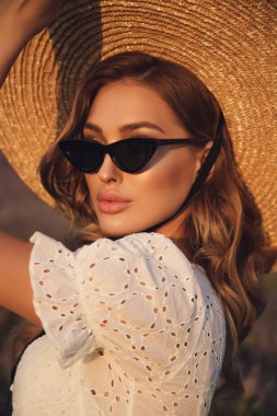 Sarışın, zarif elbiseli, özetle poz veren güzel kız.