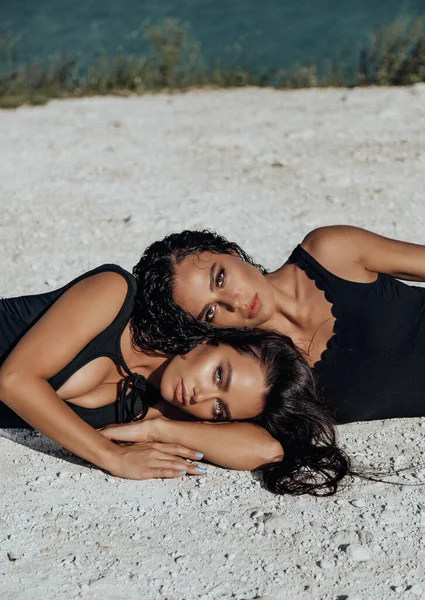两名黑发美女躺在沙滩上的户外时尚照片 — 图库照片
