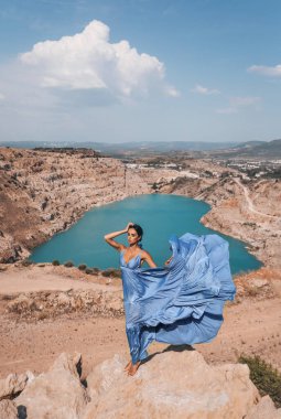 Güzel, açık hava fotoğrafında siyah saçlı, zarif elbiseli ve aksesuarlı güzel bir manzarada kalp şeklinde gölü olan güzel seksi bir kadın.