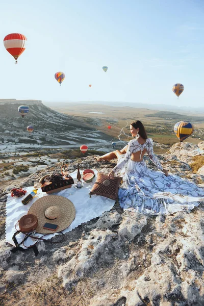 时尚的户外照片 美丽的女人 深色头发 穿着雅致的衣服 带着气球在山谷里野餐 景色迷人 — 图库照片