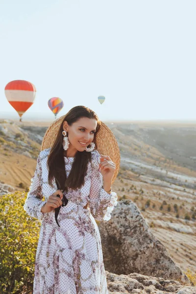 时尚的户外照片 美丽的女人 深色头发 穿着雅致的衣服 带着气球在山谷里野餐 景色迷人 — 图库照片