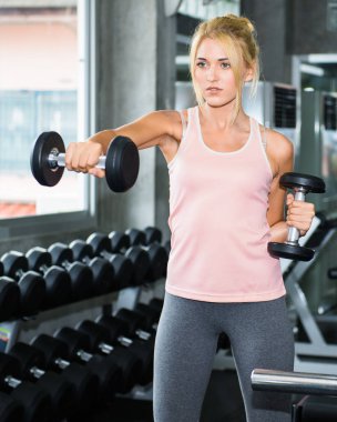 Genç kadın eğitim salonunda dumbbell ile