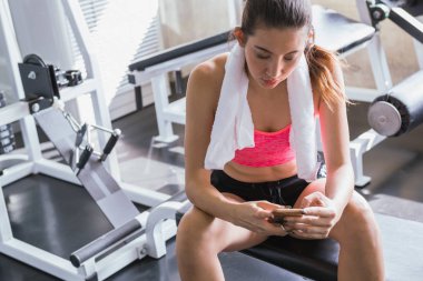 Üzerinden istirahat kadın egzersiz ve spor salonunda cep telefonu bakmak
