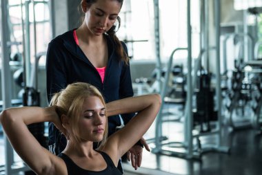 Genç kadın egzersiz İzle spor salonunda antrenörü öğretim