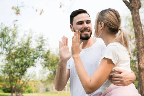 A young couple happy giving high five energetic and cheering in the park