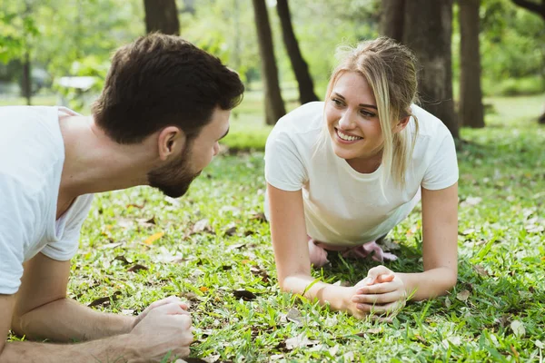 Jong koppel die zich uitstrekt in het park — Stockfoto