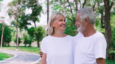 Parkta gülümseyen kıdemli mutlu çift