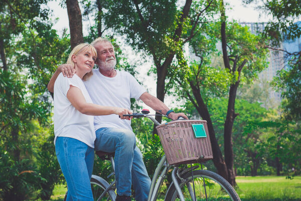 старшие пары на велосипедах в парке