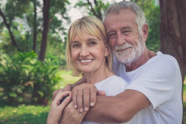 Yaşlı çift bir parkta vakit gülümseyen