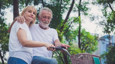 Park 'ta bisiklet süren yaşlı çift.