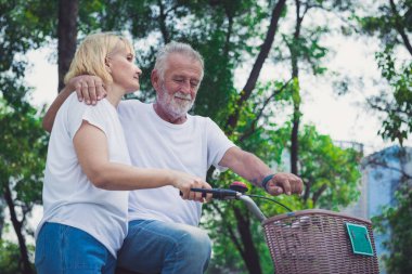 Park 'ta bisiklet süren yaşlı çift.