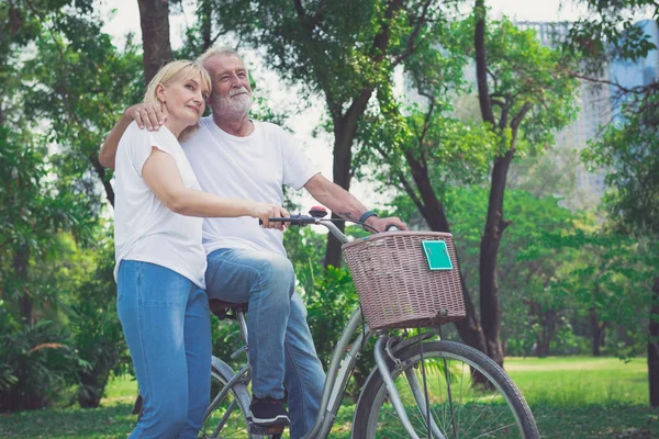 Senioren paar fietsen in park — Stockfoto