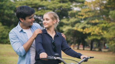 Parkta bisiklet süren mutlu bir çift..