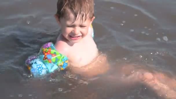 Счастливый ребенок купается в солёном озере — стоковое видео