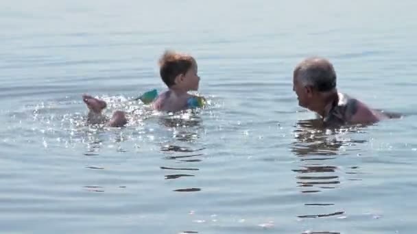 Abuelo y nieto bañándose en un lago salado — Vídeo de stock