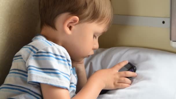 Boy playing cellphone games in train — Stock Video