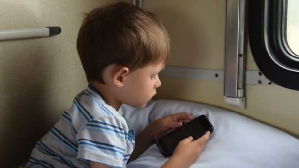 Boy playing mobile games in train — Stock Video