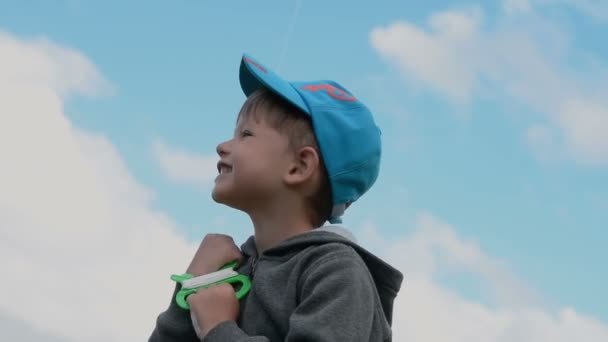 Щасливий маленький хлопчик проти неба — стокове відео