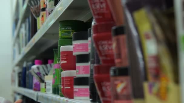 Женщина покупает косметику для лица в магазине — стоковое видео