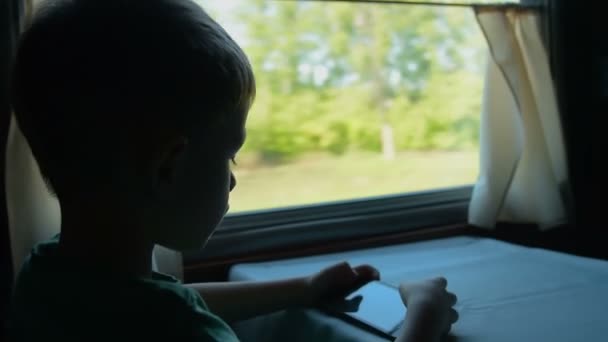 Enfant jouant jeu mobie dans le train — Video