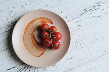 Taze vişneli domatesler beyaz masa arkasında, üst tarafta. Olgun sebzeler