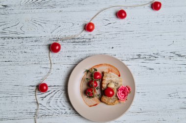 Domuz eti, ızgara ve beyaz ahşap masada vişneli domatesle servis edilir.