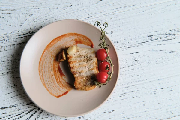 Pork steak, grilled and served with cherry tomatoes on white wood table — Stock Photo, Image