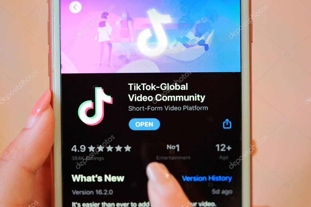 Nakhonratchasima, Thailand - May 31, 2020 : Tik Tok application information icon on Apple iPhone 8 close-up,finger about to touch it.which is a popular social media network is app to create and share videos on the internet.